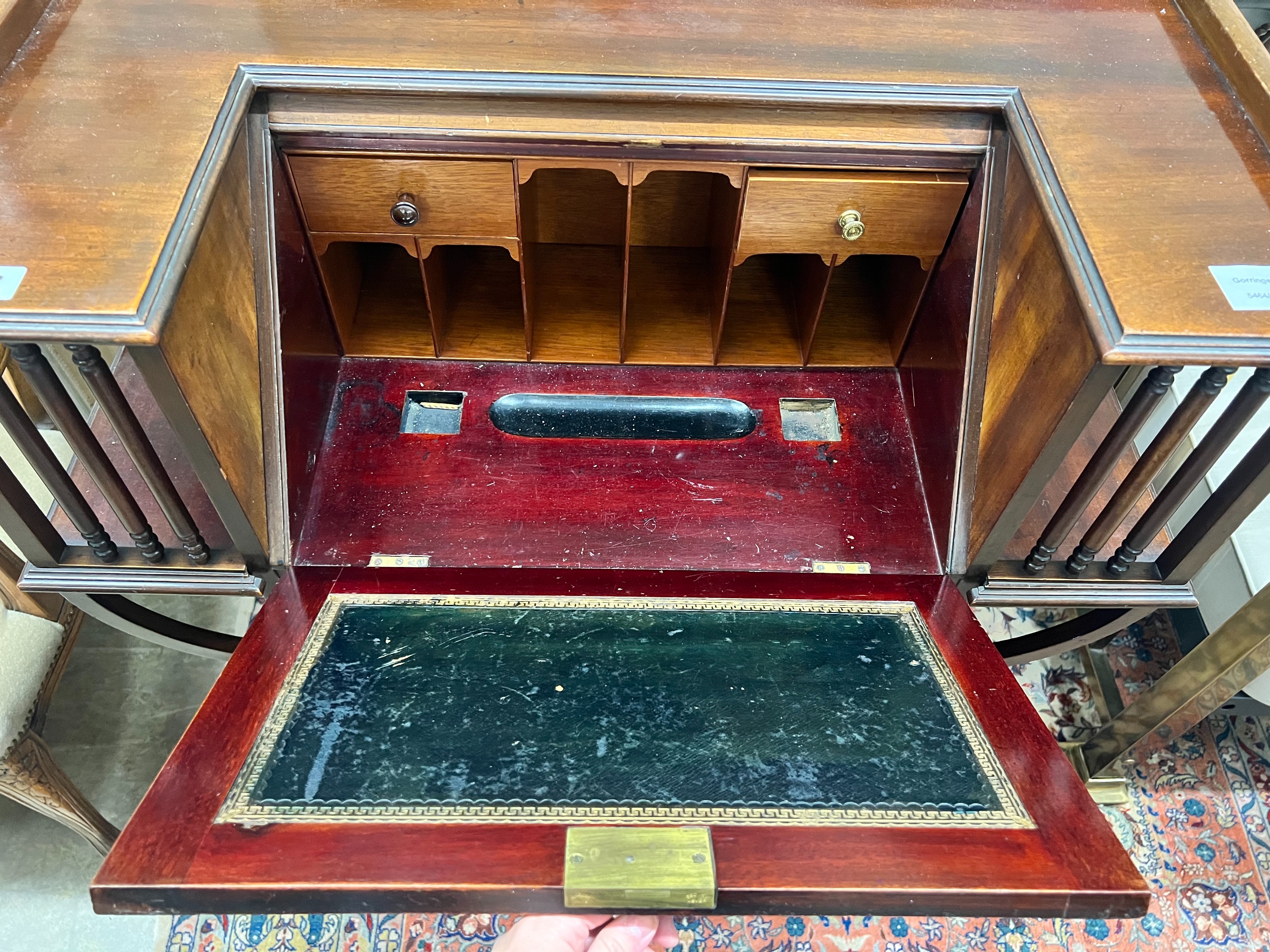 A late Victorian mahogany bureau, rectangular top with moulded ledge back and inset panelled writing slope, projecting bookshelves to the sides spaced with turned supports‘ drawers and cupboard doors, on cabriole support